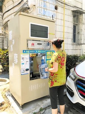 5月24日，瓊山區(qū)上丹花苑小區(qū)居民陳女士在使用共享凈水機(jī)取水。 本報(bào)記者 陳歆卓 攝